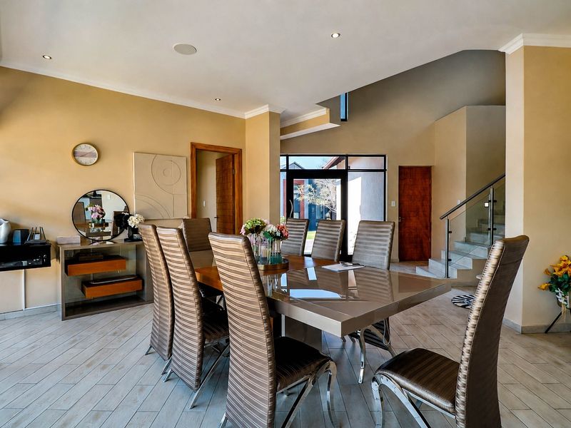Spacious dining area featuring tiled flooring, recessed lighting, and an open-plan layout with a staircase and access to the exterior.