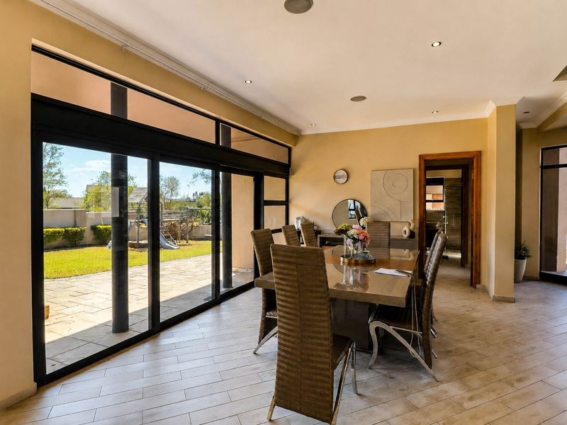 Spacious dining room featuring large sliding glass doors that provide seamless access to the outdoor patio and garden area.