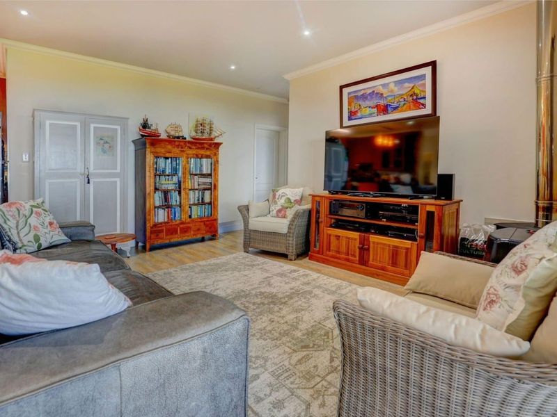 A comfortable living room featuring recessed downlighting, coving, and a built-in wood-burning fireplace, creating a warm and inviting atmosphere.