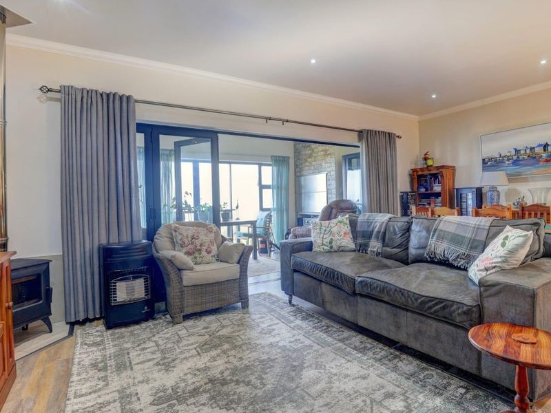 A comfortable living room featuring a wood-burning stove, recessed lighting, and large sliding glass doors that open onto an adjacent patio area.