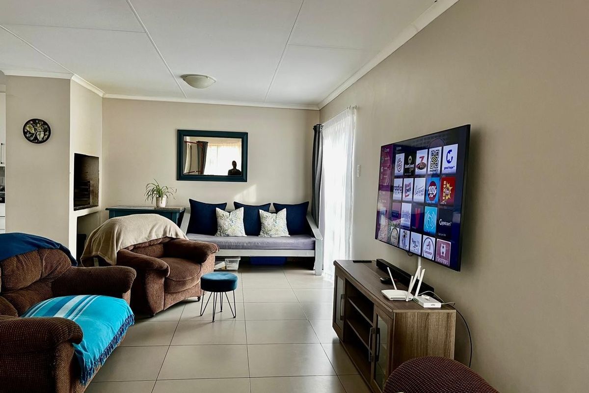 A comfortable living room featuring tiled flooring, a built-in fireplace, and a sliding glass door providing natural light.