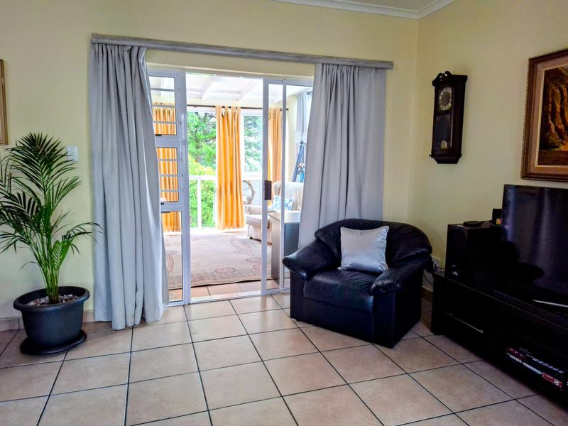 Living room featuring tiled flooring and a sliding glass door providing access to an outdoor patio area.