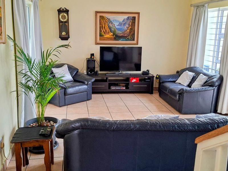 A comfortable living room featuring tiled flooring and neutral wall finishes, providing a functional space for relaxation and entertainment.