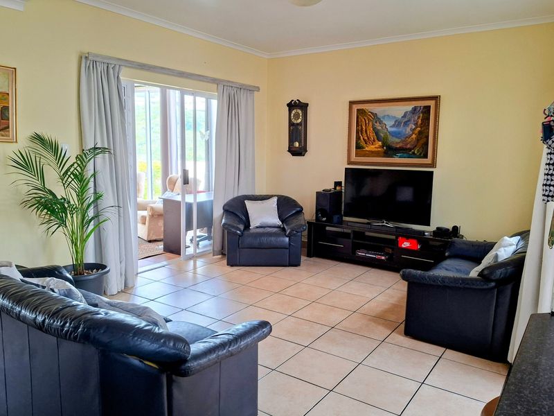 Spacious living room featuring neutral tiled flooring and a large sliding glass door providing direct access to the outdoor patio area.