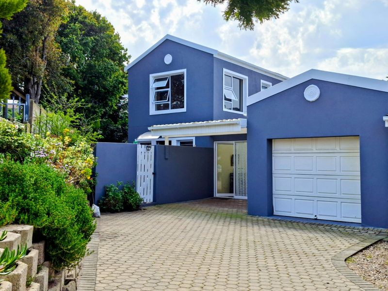 Front elevation of a two-story duet property featuring a paved driveway, single garage, and a private pedestrian entrance.