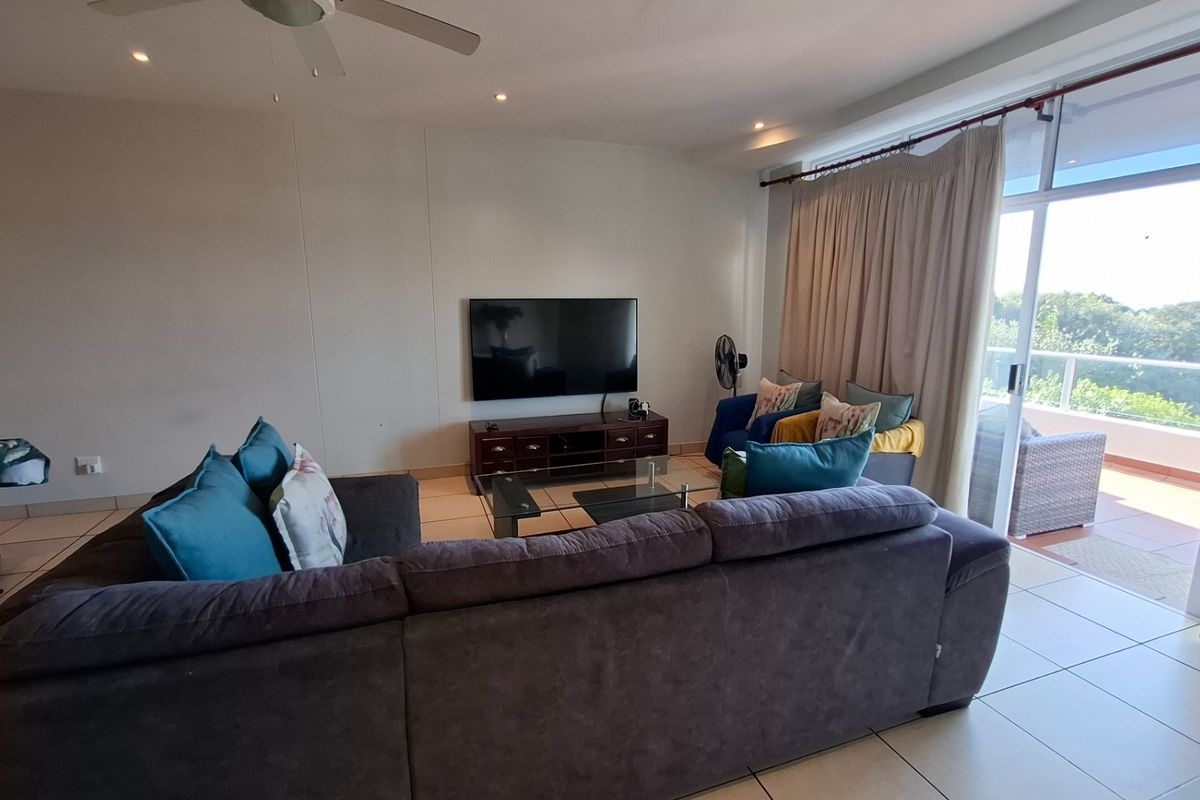 Spacious living room featuring tiled flooring, recessed lighting, a ceiling fan, and direct access to a balcony through large sliding glass doors.