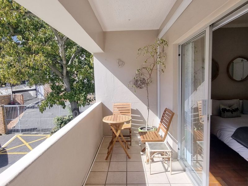 A covered balcony featuring tiled flooring and a sliding glass door providing access to the interior living space.