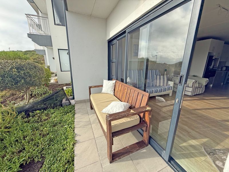 A covered patio area featuring tiled flooring and large sliding glass doors that provide seamless access to the interior living space.