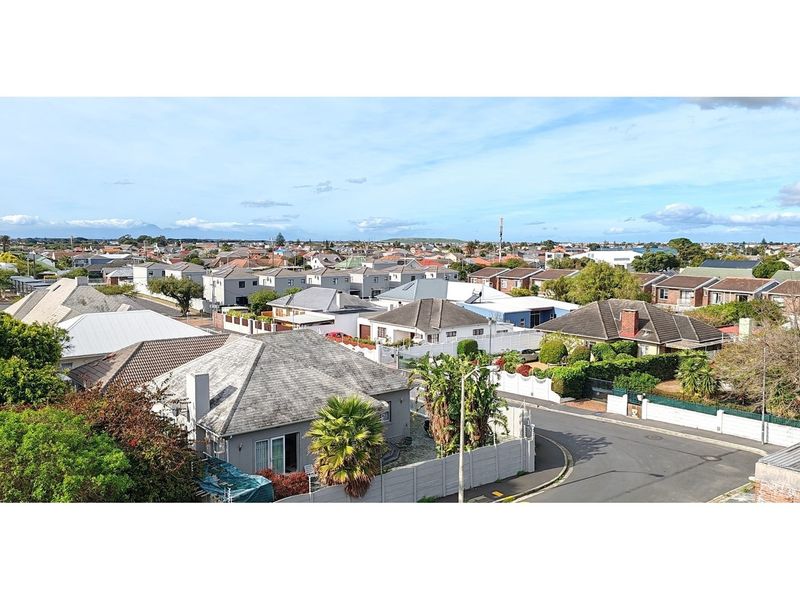 An elevated aerial view overlooking a suburban residential neighborhood with various houses, streets, and landscaped gardens.