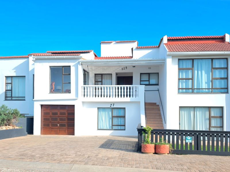 A well-maintained double-story residential property featuring a paved driveway, integrated garage, and an upper-level balcony with a classic balustrade.