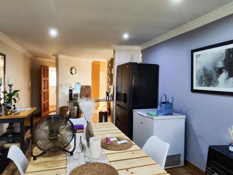 Open plan living and dining area featuring tiled flooring, recessed downlighting, and decorative cornice detailing throughout the space.