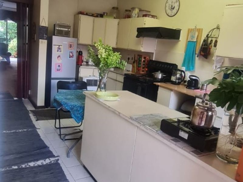 A functional kitchen featuring built-in cabinetry, a central island, and tiled flooring, offering a practical layout for daily meal preparation.
