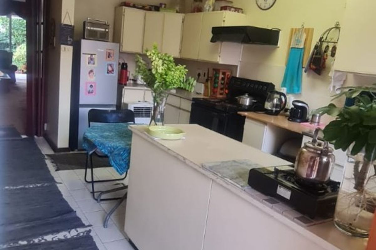 A functional kitchen featuring built-in cabinetry, a central island, and tiled flooring, offering a practical layout for daily meal preparation.