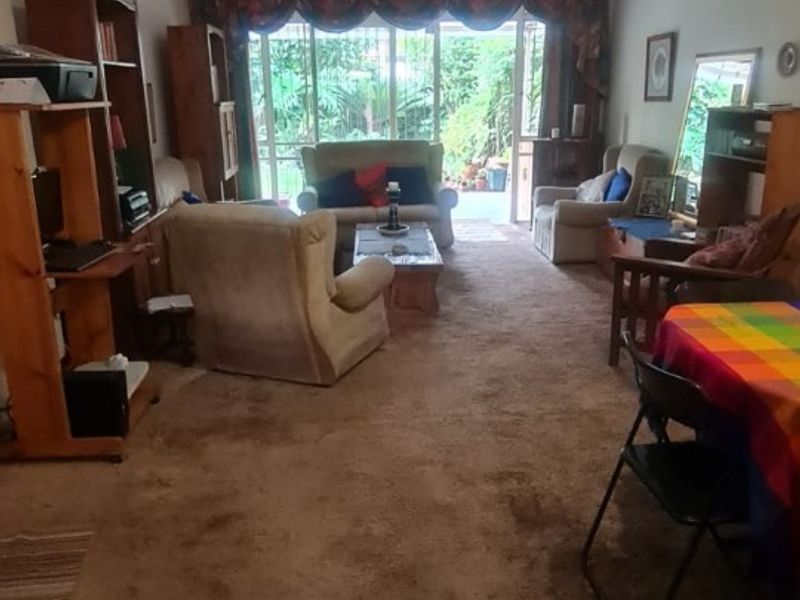Spacious living area featuring wall-to-wall carpeting and large sliding glass doors providing access to the rear garden area.