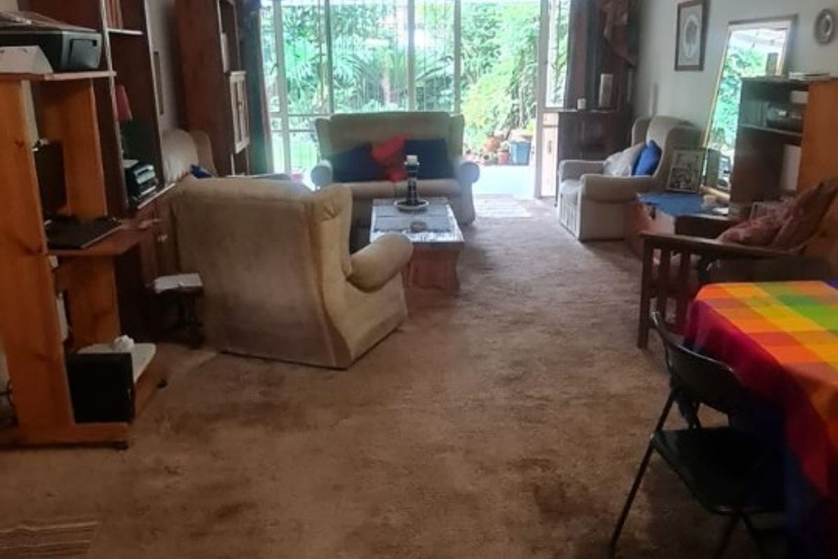 Spacious living area featuring wall-to-wall carpeting and large sliding glass doors providing access to the rear garden area.