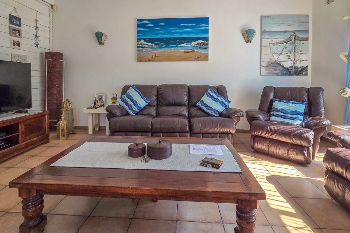 A comfortable living room featuring tiled flooring and wall-mounted lighting fixtures, providing a functional and inviting space for relaxation.