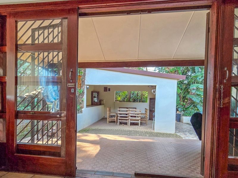 A covered outdoor patio area featuring tiled flooring and sliding timber doors, providing a seamless transition between indoor and outdoor living spaces.