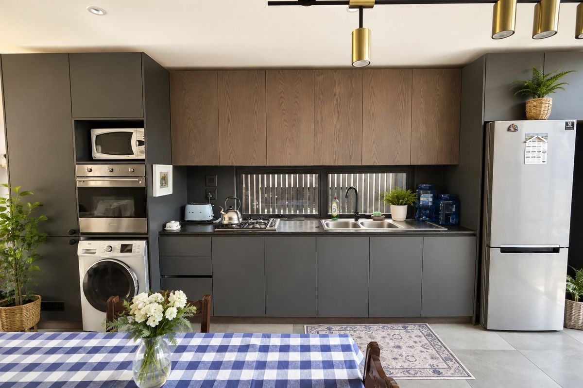 Modern kitchen featuring dark grey cabinetry, wood-tone upper cabinets, built-in oven and microwave, gas hob, and double sink with contemporary lighting.