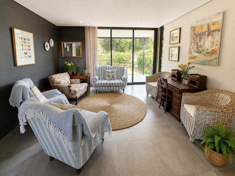 A bright and well-maintained living room featuring large sliding glass doors that provide natural light and direct access to the outdoor garden area.
