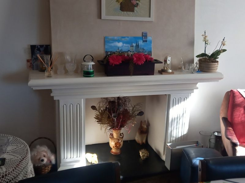 A living room featuring a classic white fireplace mantel and hearth, serving as a central focal point for the space.