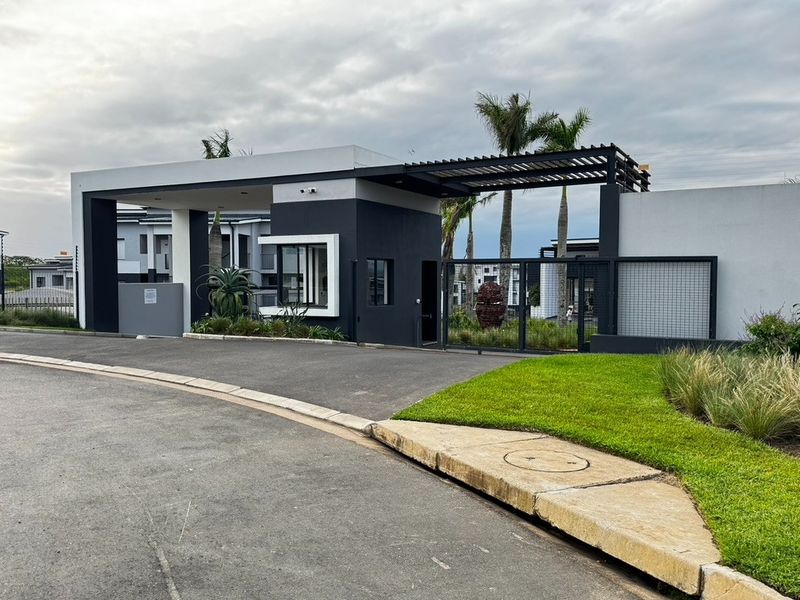 Modern security gatehouse and entrance to the apartment complex, featuring contemporary architectural design, automated access control, and well-maintained landscaping.