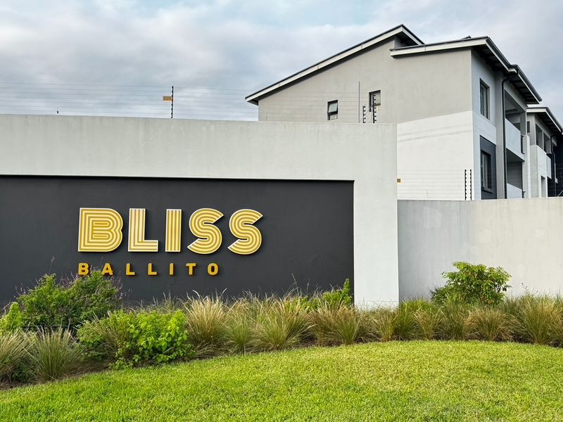 The entrance signage and boundary wall of the Bliss Ballito apartment complex, featuring modern architectural finishes and well-maintained landscaping.