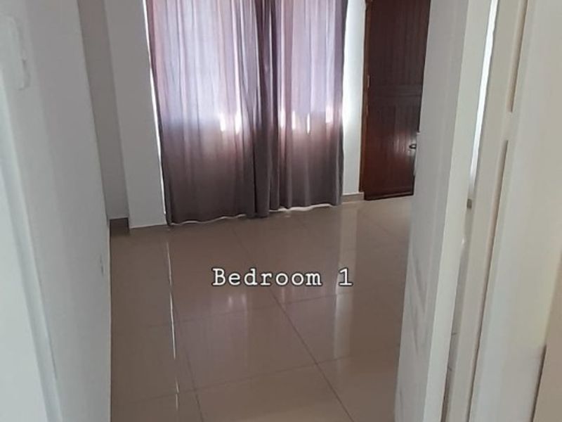 An empty bedroom featuring neutral tiled flooring and a standard internal door, offering a blank canvas for personalization.