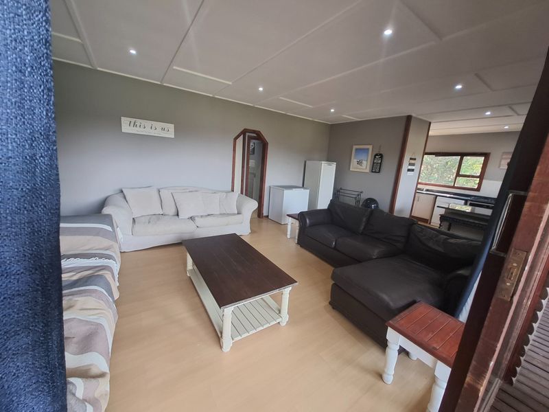 Spacious open-plan living area featuring laminate flooring, recessed lighting, and a connected kitchen space, offering a versatile layout for family living.