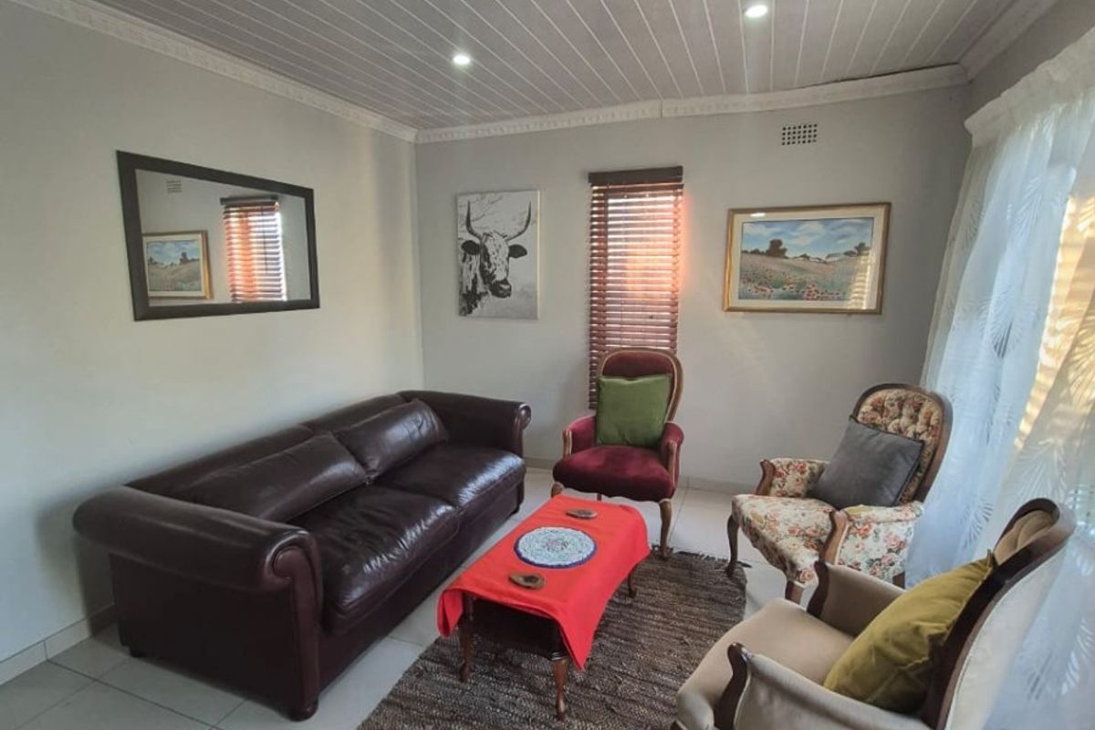 A living room featuring tiled flooring, a tongue and groove ceiling with recessed lighting, and venetian blinds.