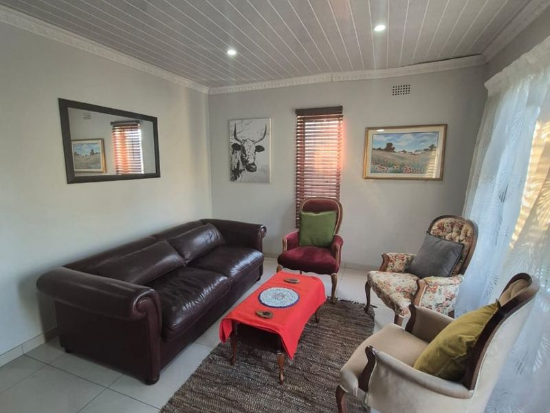 A living room featuring tiled flooring, a tongue and groove ceiling with recessed lighting, and venetian blinds.