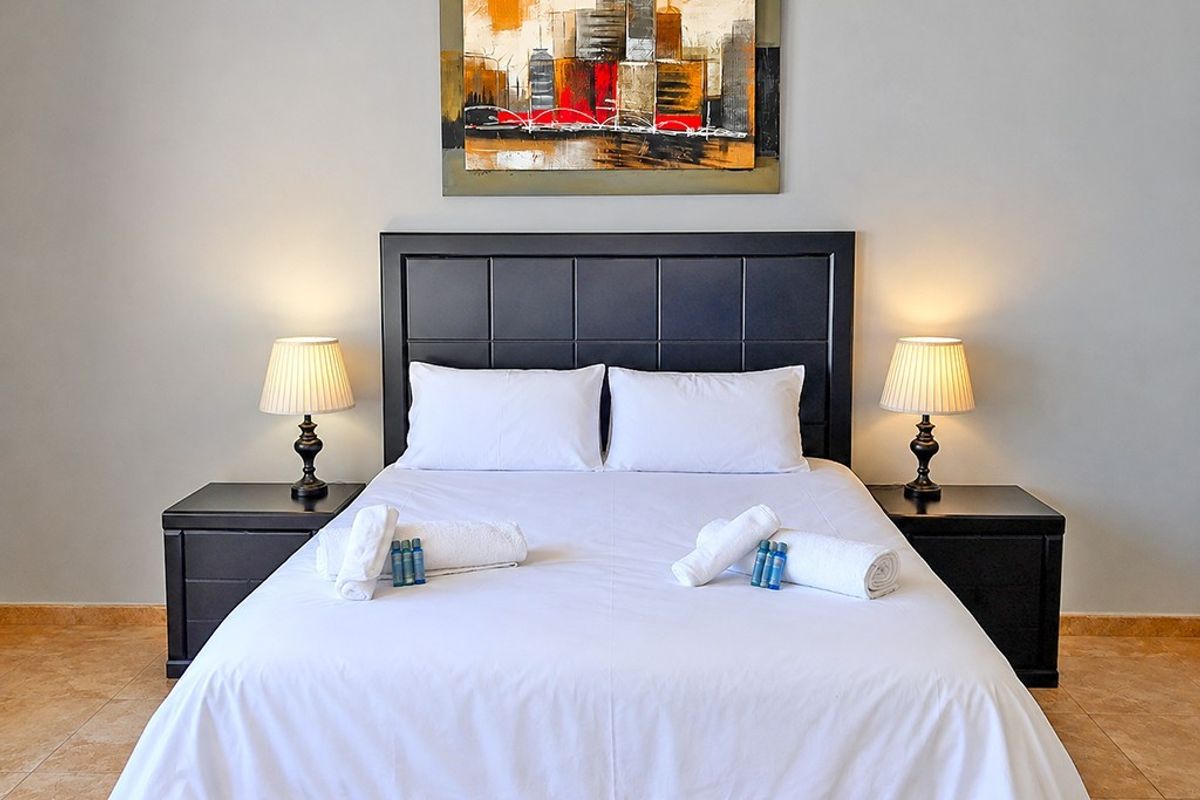 A well-maintained bedroom featuring neutral wall tones and durable tiled flooring, providing a clean and comfortable sleeping space.