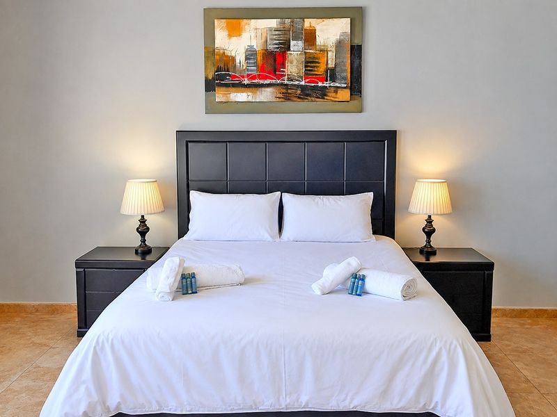 A well-maintained bedroom featuring neutral wall tones and durable tiled flooring, providing a clean and comfortable sleeping space.
