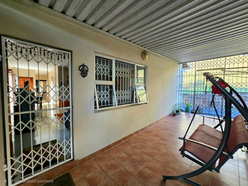 A covered patio area featuring tiled flooring, a corrugated metal roof, and security fixtures on the windows and entrance door.