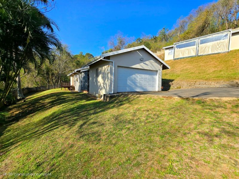 Exterior view of a townhouse featuring a single garage, asphalt driveway, and surrounding sloped lawn area.