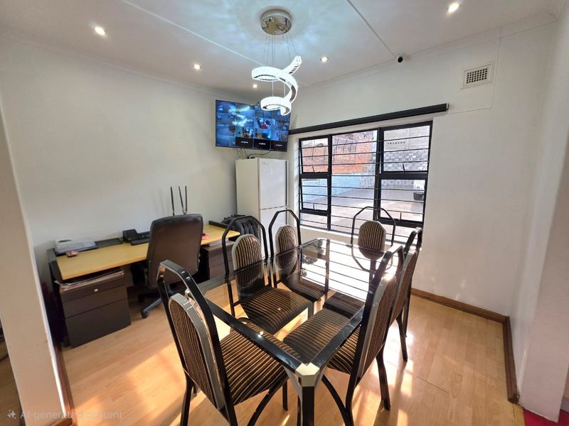 A functional dining room featuring laminate flooring, recessed lighting, and security bars on the windows, currently utilized as a multi-purpose dining and workspace area.