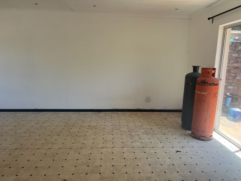 An empty living room featuring vinyl tile flooring, recessed lighting, and a sliding glass door providing access to the exterior.