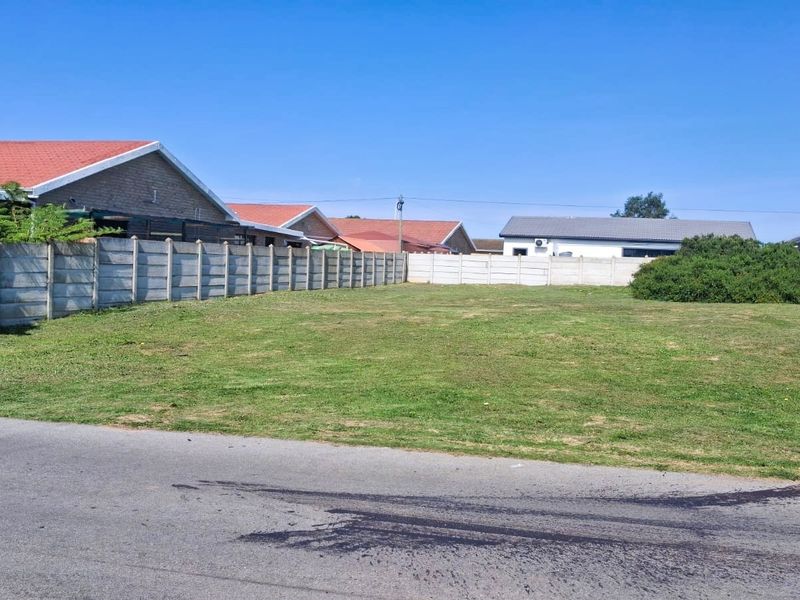 A vacant residential plot featuring a level grass lawn and enclosed by precast concrete boundary walls, situated in a developed neighbourhood.