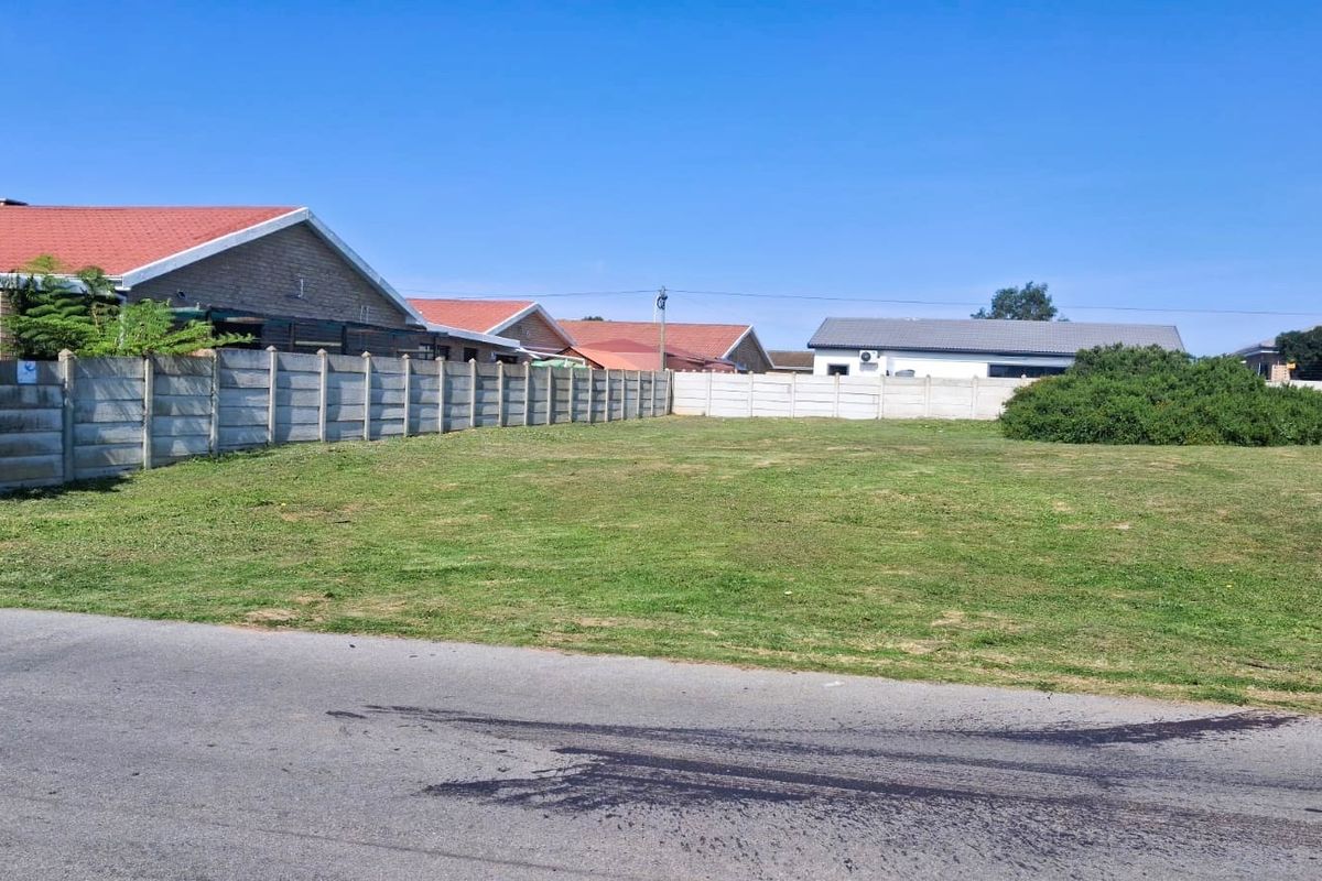 A vacant residential plot featuring a level grass lawn and enclosed by precast concrete boundary walls, situated in a developed neighbourhood.