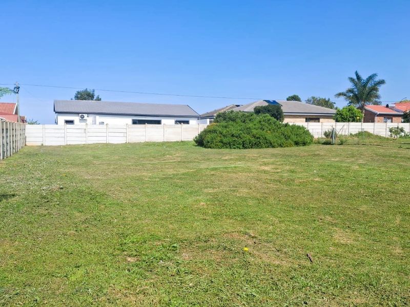 A spacious, level residential plot featuring a well-maintained lawn and secure precast concrete boundary walls, offering a clear space for future development.
