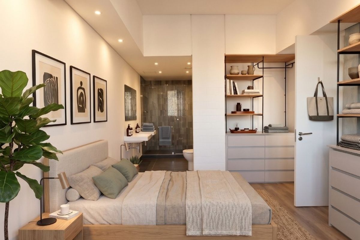 Modern bedroom featuring integrated wardrobe storage, recessed and track lighting, and an open-plan en-suite bathroom with contemporary finishes.