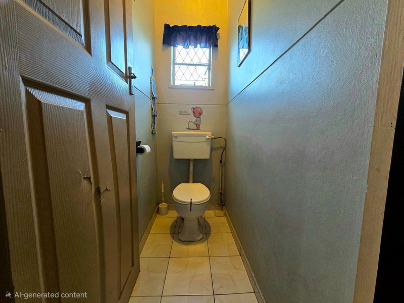 A small, functional guest toilet featuring tiled flooring and a leaded glass window, currently in need of cosmetic updates and door repairs.