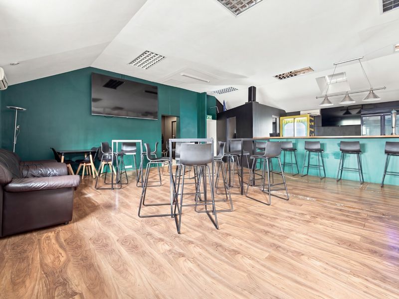 Spacious office bar area featuring a built-in counter, laminate wood flooring, recessed lighting, and split-system air conditioning units.
