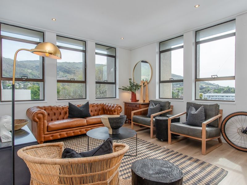 Bright and airy living room featuring large windows with mountain views, recessed downlighting, and light timber flooring.