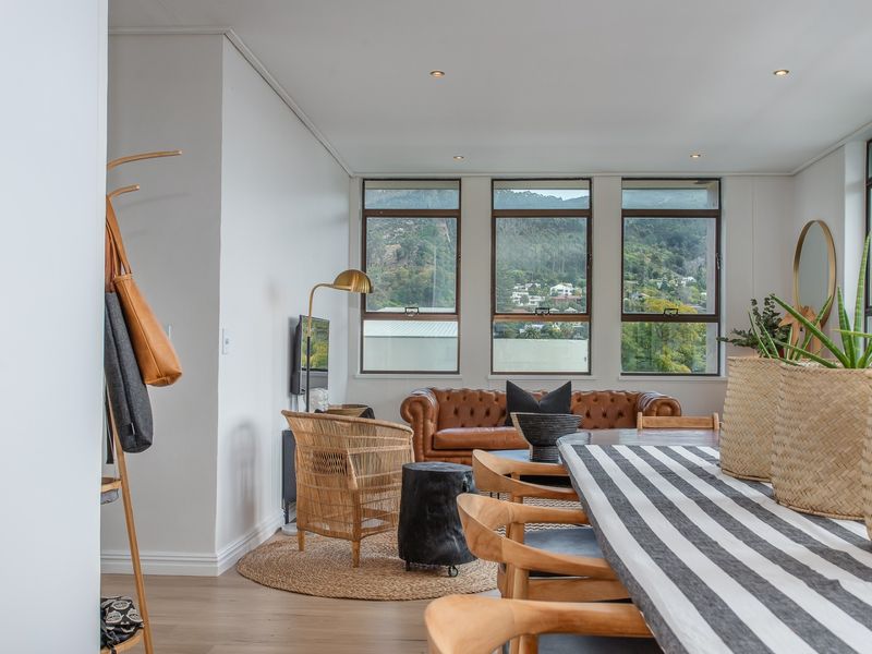 Bright open-plan living and dining area featuring large windows with scenic mountain views, recessed lighting, and modern laminate flooring.