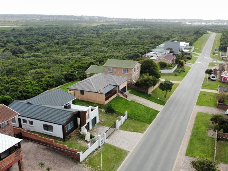 Aerial view of the residential property showing the roof structure, driveway, and surrounding neighborhood landscape.