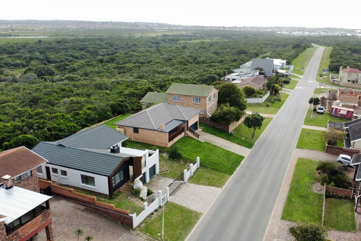 Aerial view of the residential property showing the roof structure, driveway, and surrounding neighborhood landscape.