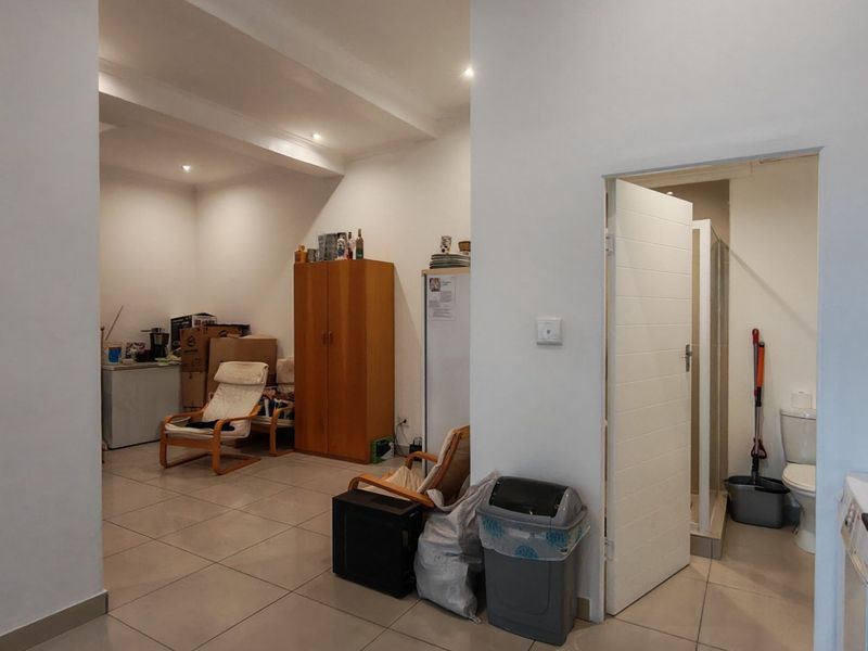 Open plan living area with tiled flooring and recessed lighting, featuring direct access to an adjacent bathroom.