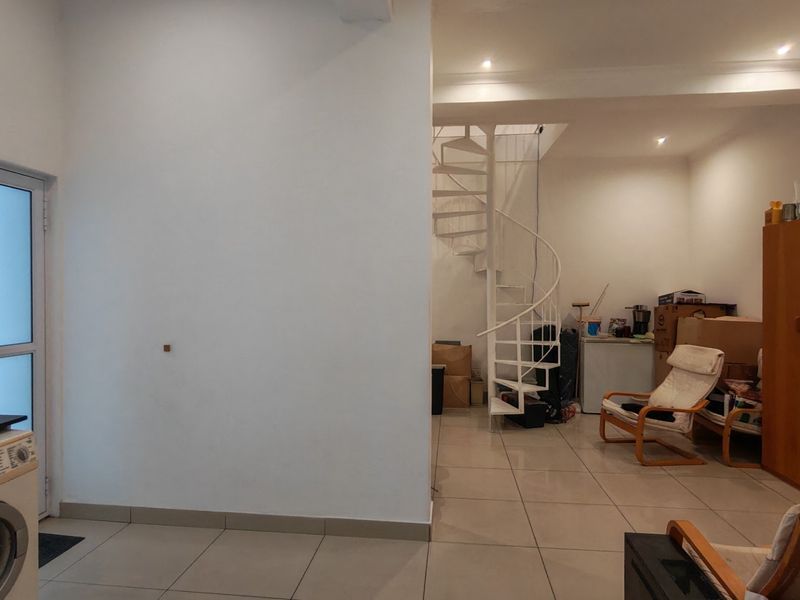 Open plan living area featuring tiled flooring, recessed lighting, and a white spiral staircase leading to the upper level.