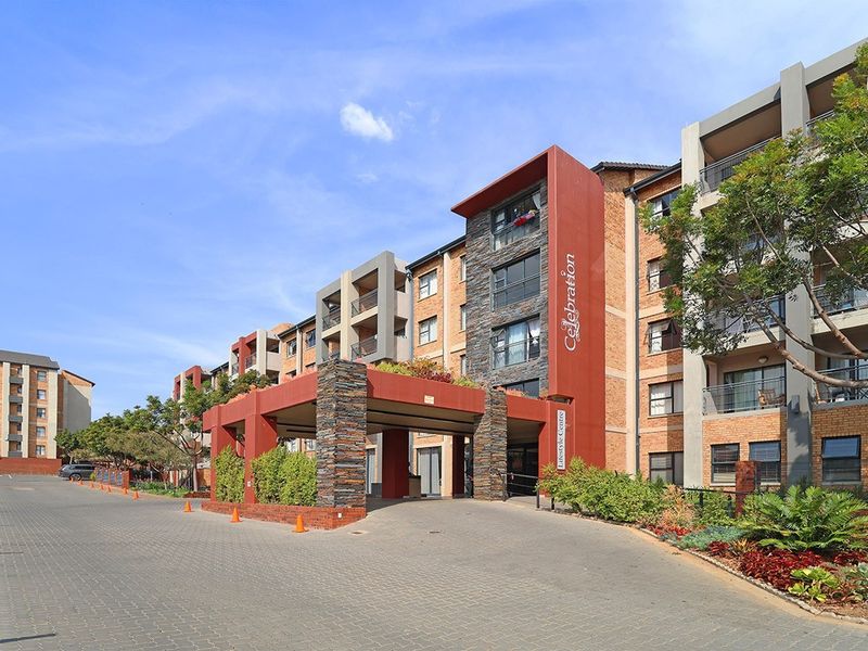 Front exterior view of the retirement village lifestyle centre, featuring a modern brick and stone facade with a covered entrance portico and paved driveway.