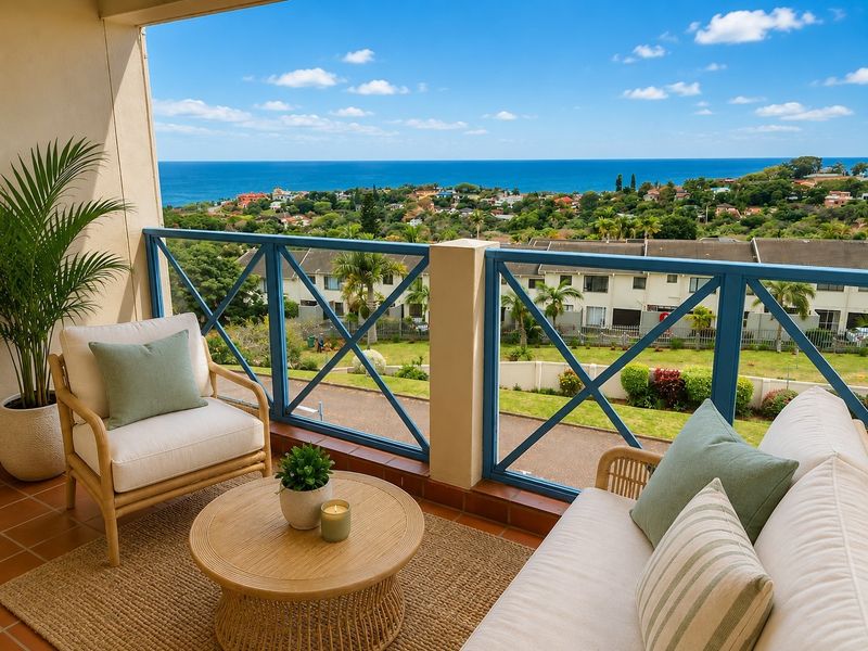A covered balcony featuring terracotta tiling and a blue metal balustrade, offering expansive coastal and neighbourhood views.